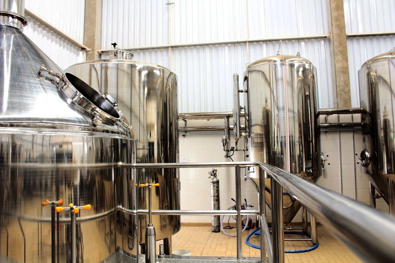 Stainless steel industrial tanks and piping in a modern adhesive manufacturing facility