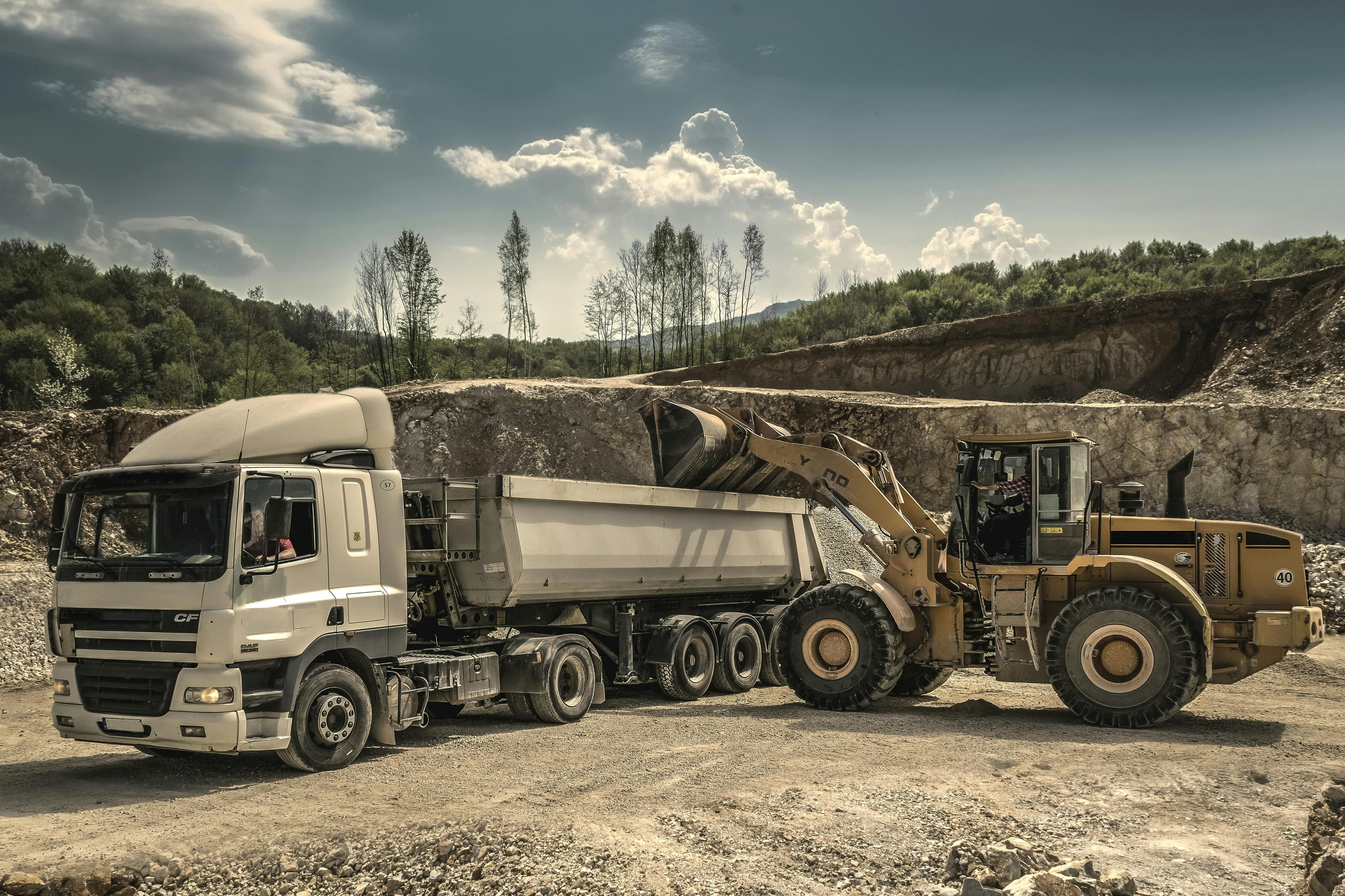 Front-end loader and dump truck for bulk material transfer in mining and construction