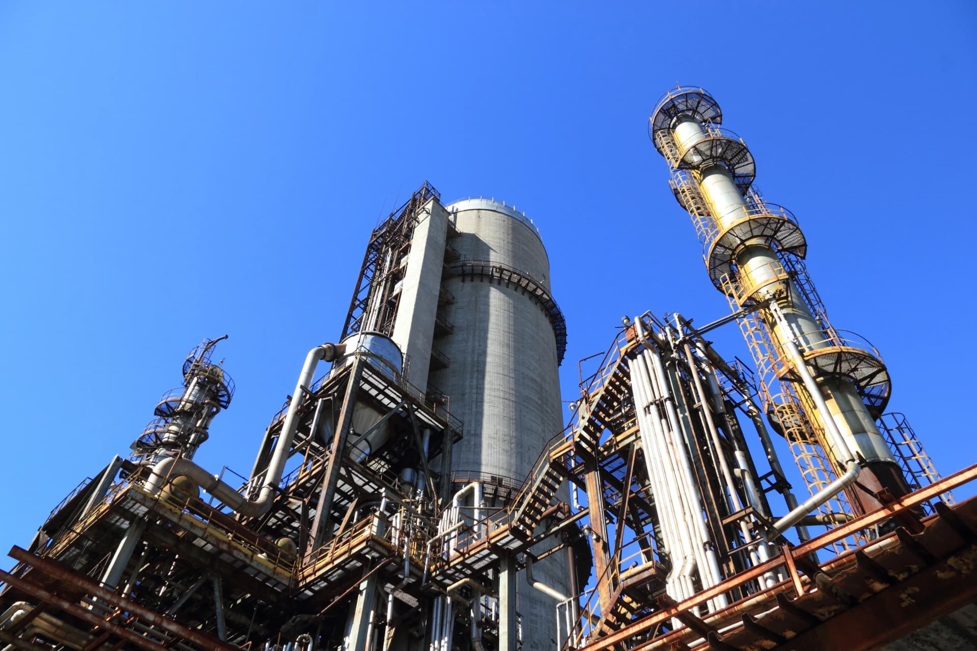 Industrial refinery with piping columns and processing towers: facilities where both gear pumps and centrifugal pumps operate