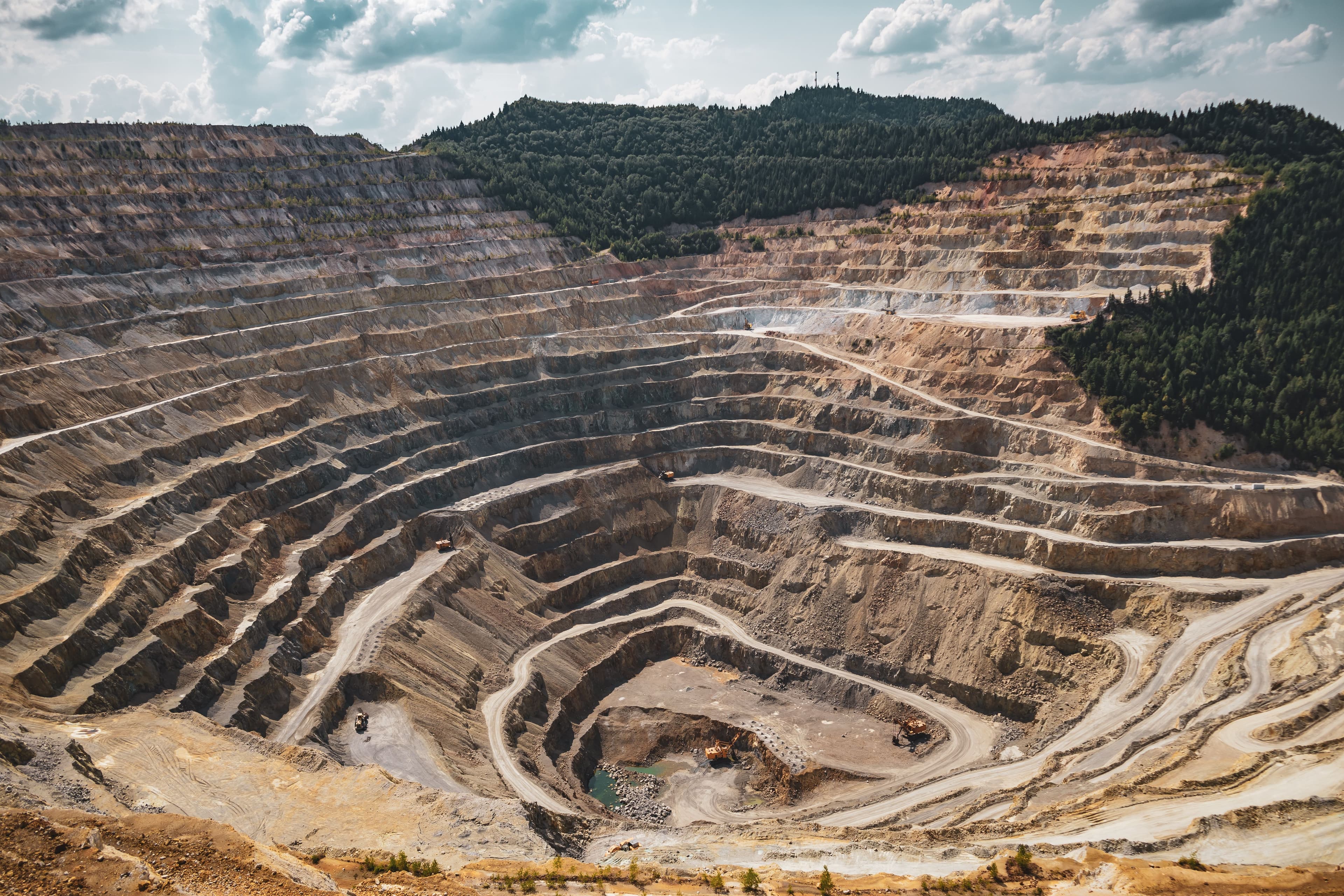 Mining excavation on mountain with heavy equipment and earth moving operations