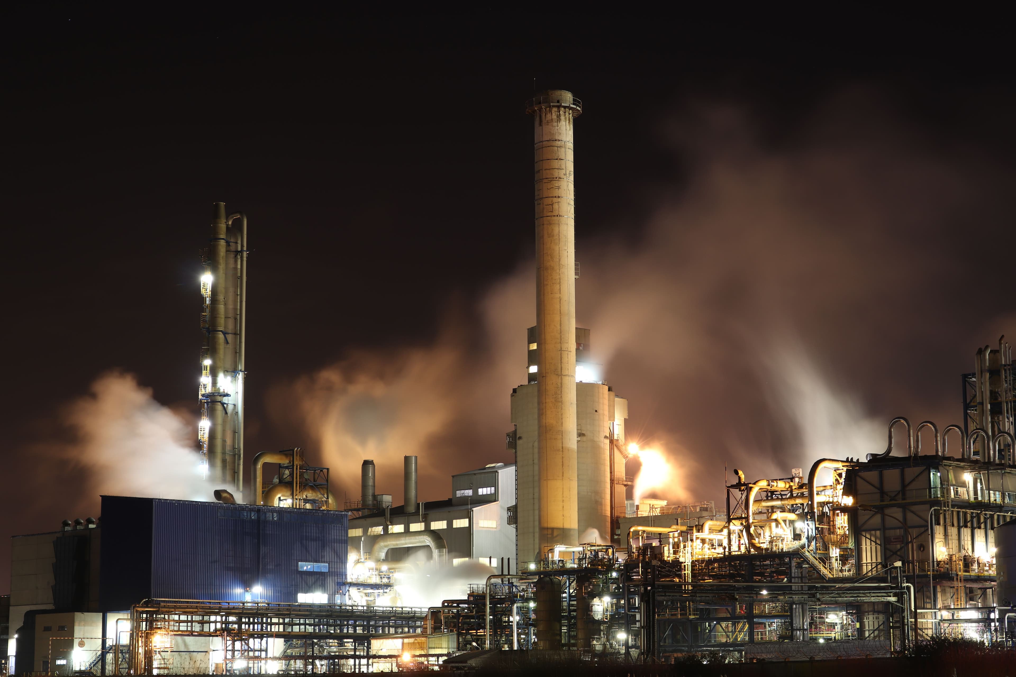 Chemical manufacturing plant with processing towers and steam — industrial facilities that use gear pumps for adhesive and sealant transfer
