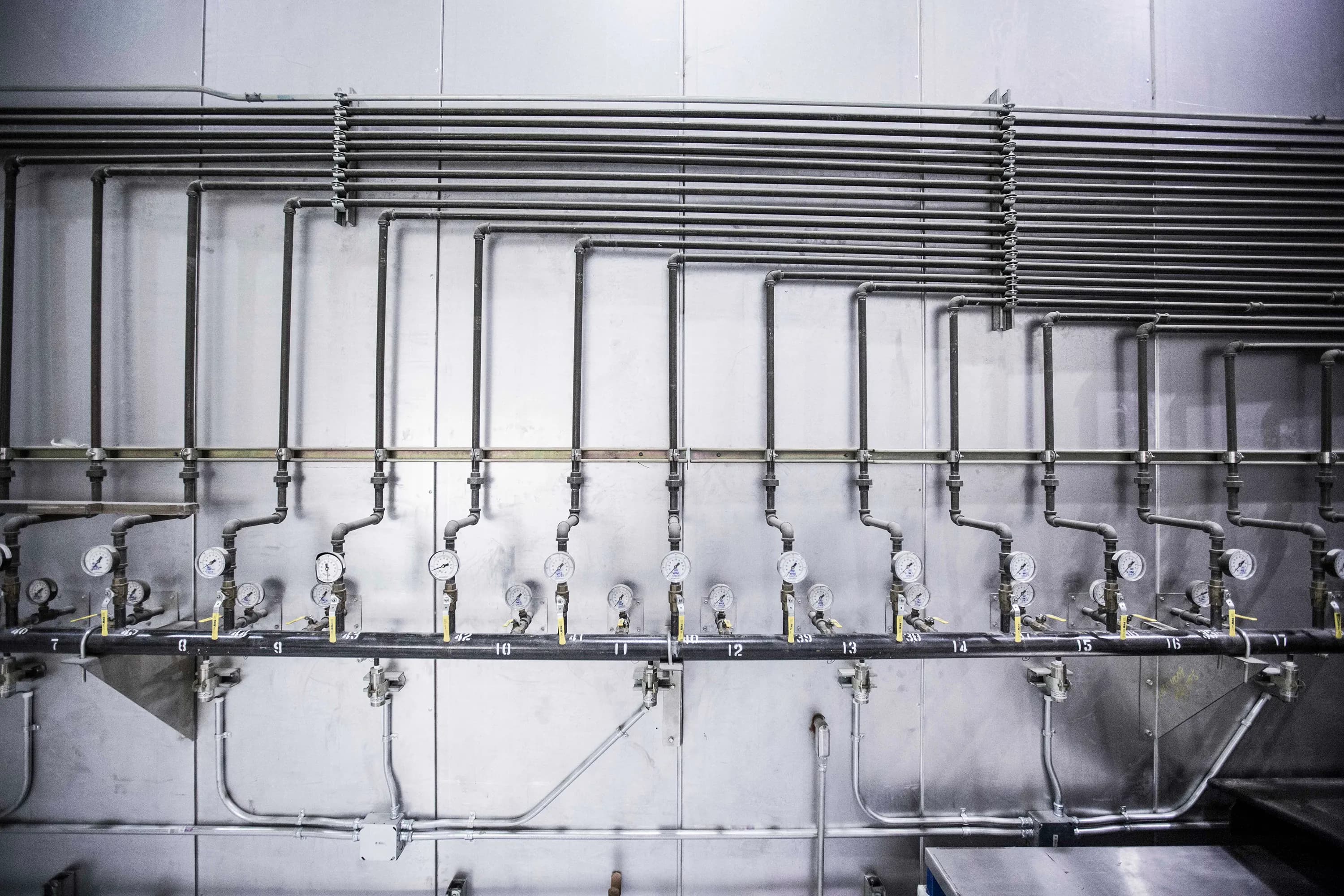 Industrial steel pipe system with pressure gauge for pump monitoring