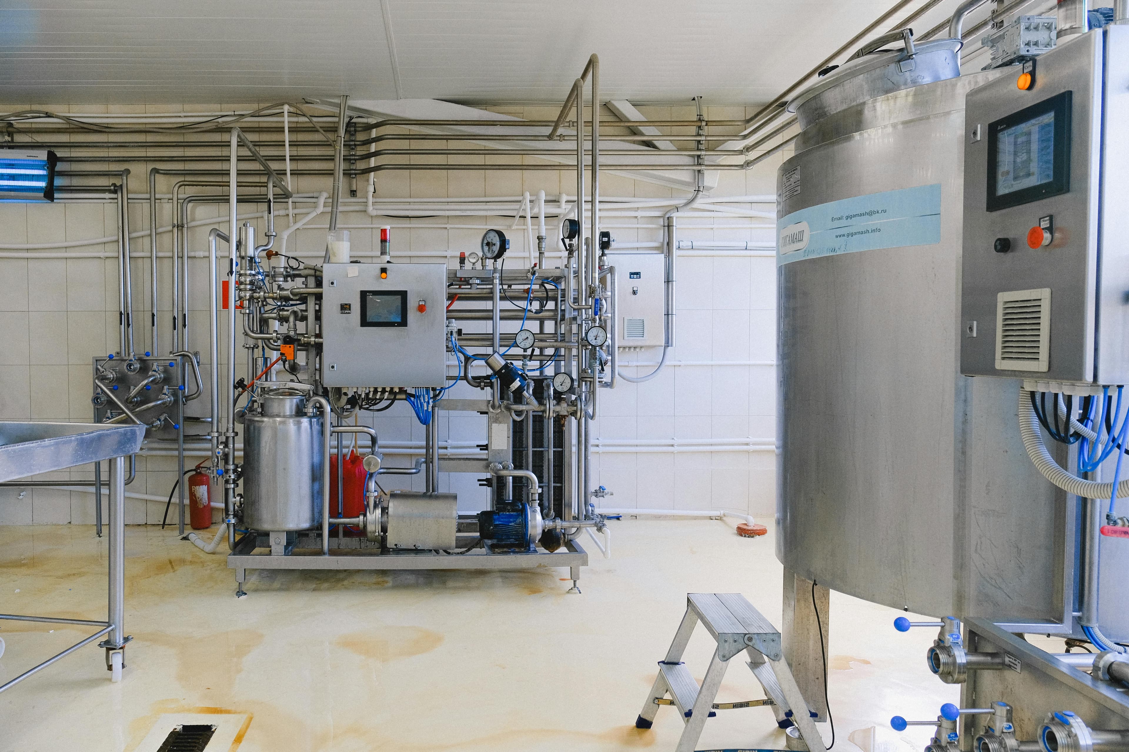 Stainless steel food processing room with sanitary tank, pump, and piping system in a clean production environment