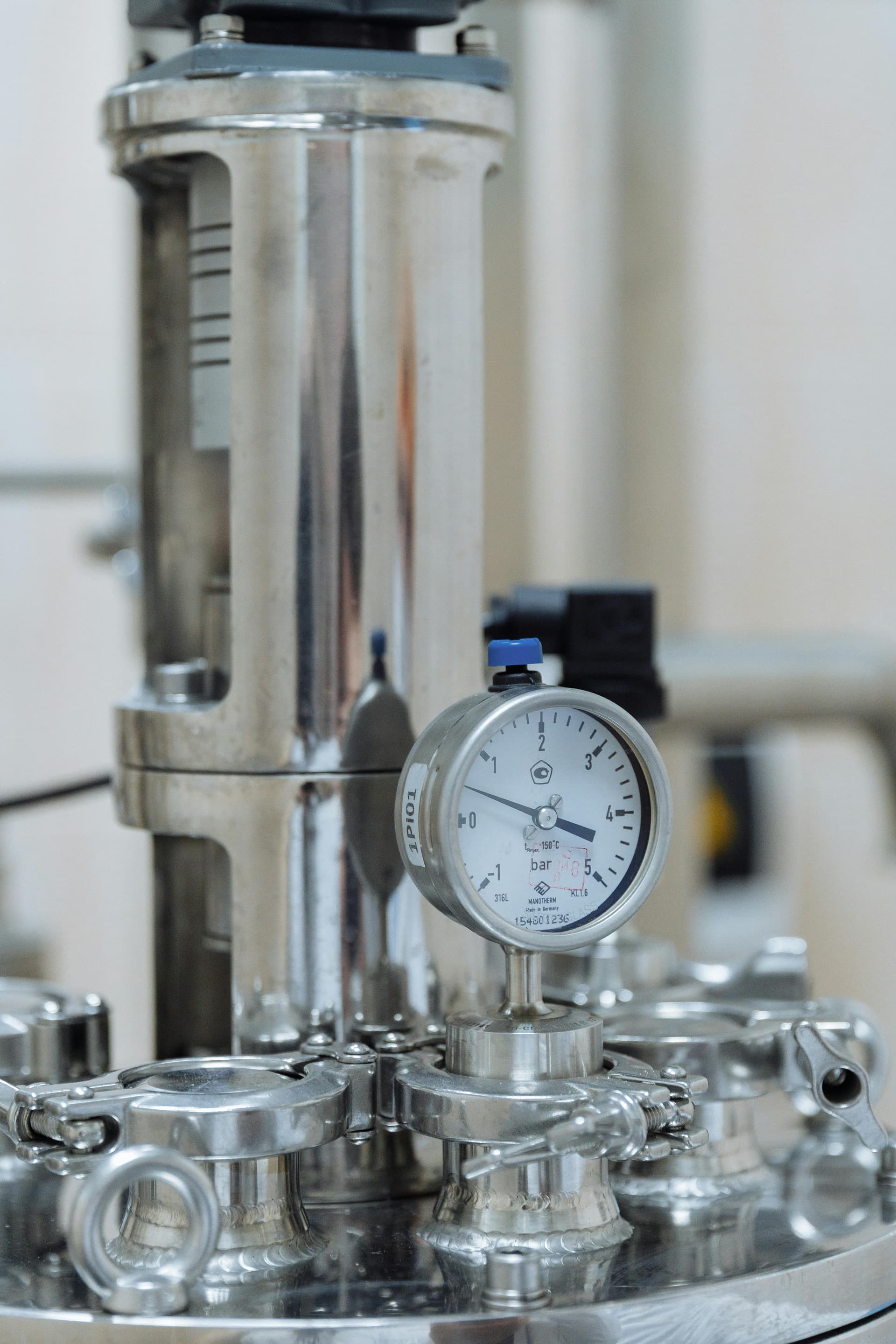 Stainless steel pressure vessel with gauge and sanitary fittings — precision components used in gear pump fluid systems